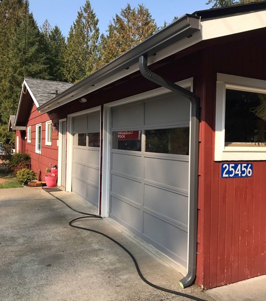 New gutters and downspouts installed on garage